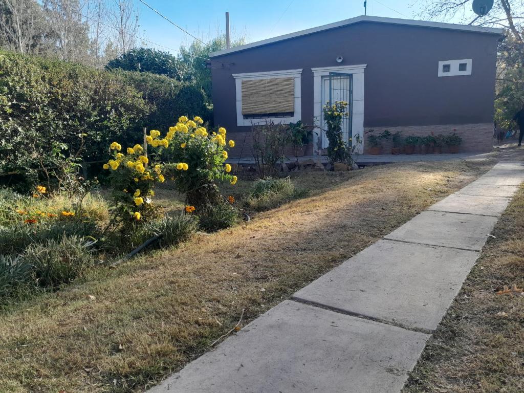 una casa con flores amarillas en el patio en Los Carolinos en San Rafael