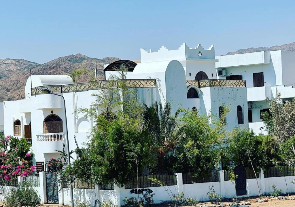 a white house with a fence in front of it at Villa Andalusia Dahab blue in Dahab