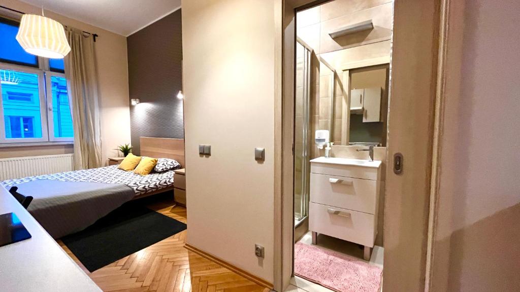 a small room with a bed and a mirror at Double Studio City Center in Krakow