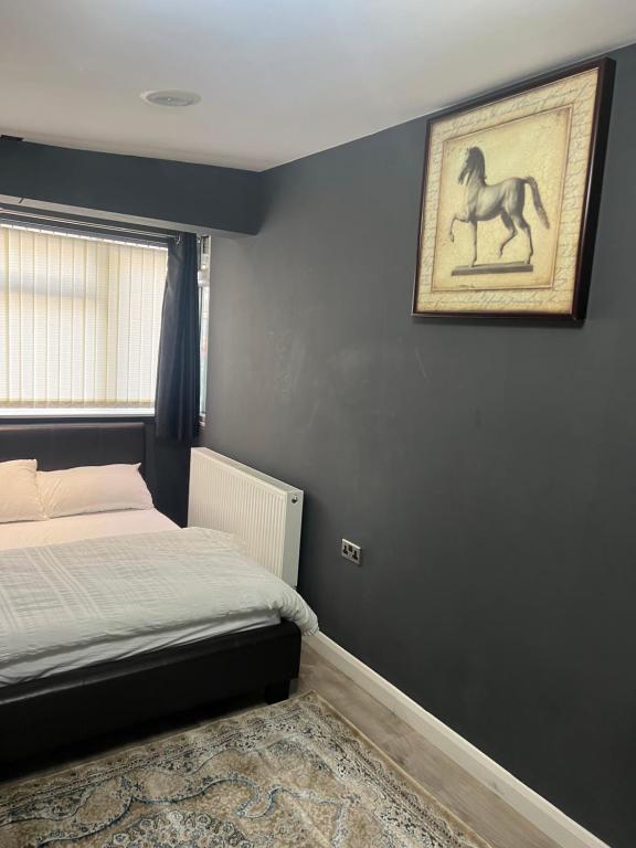 a bedroom with a bed and a painting of a horse on the wall at Rooms in Surrey in Laleham