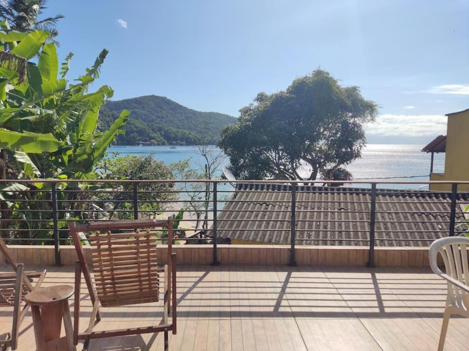 a balcony with chairs and a view of the water at Lopes House Araçatiba in Praia de Araçatiba