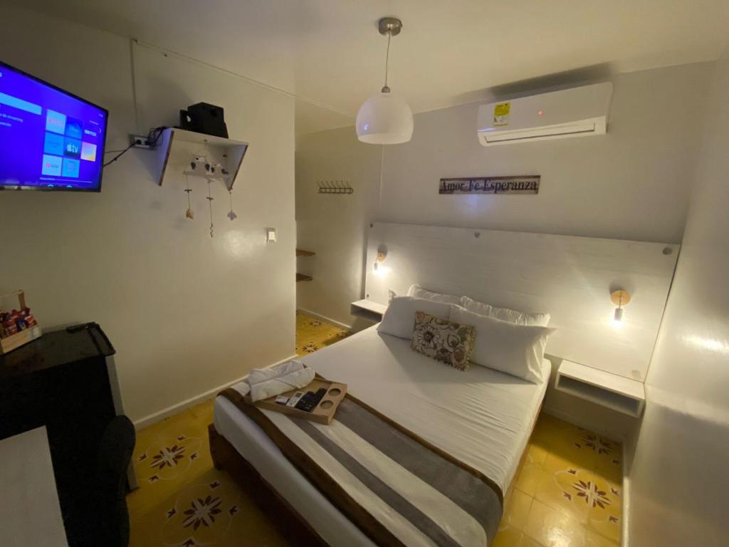 a small room with a bed and a tv at Hotel Nogales Riohacha in Ríohacha