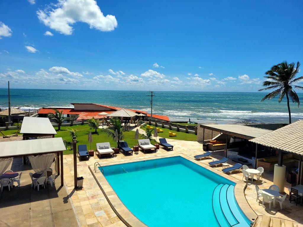 uma piscina com o oceano ao fundo em Sunset Beach Hotel em Taíba