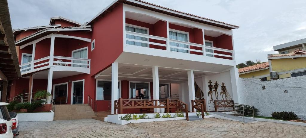 Casa rossa e bianca con balcone. di Pousada Litorânea a São Luís