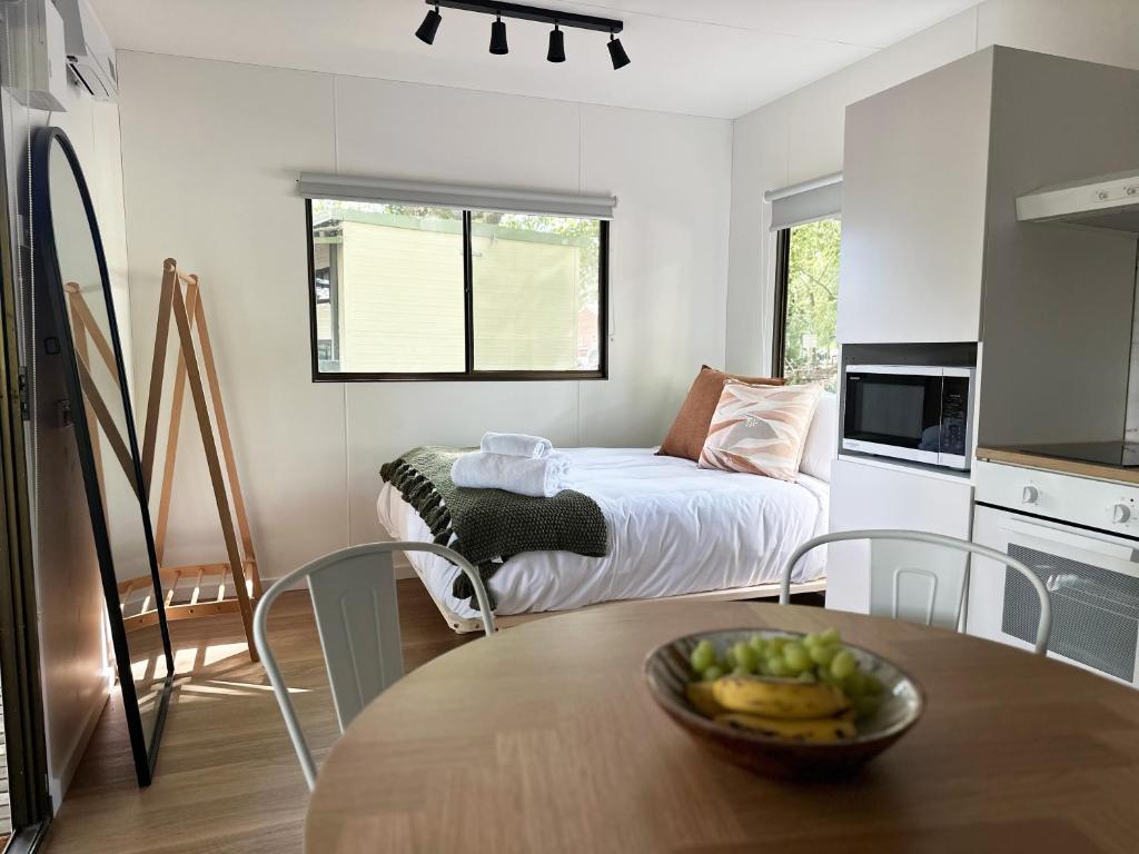 a kitchen with a table with a bowl of fruit on it at Tawonga Tourist Park in Tawonga