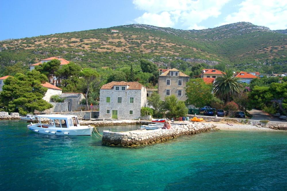 Un barco está atracado en un muelle en el agua. en Apartments Petković, en Kućište