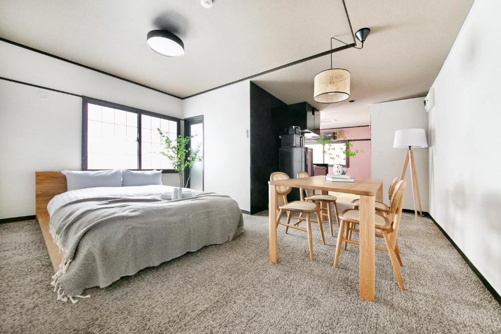 Un dormitorio con una cama y una mesa y sillas. en ぷふか芝公園　(Pufuka Shibakoen), en Tokio