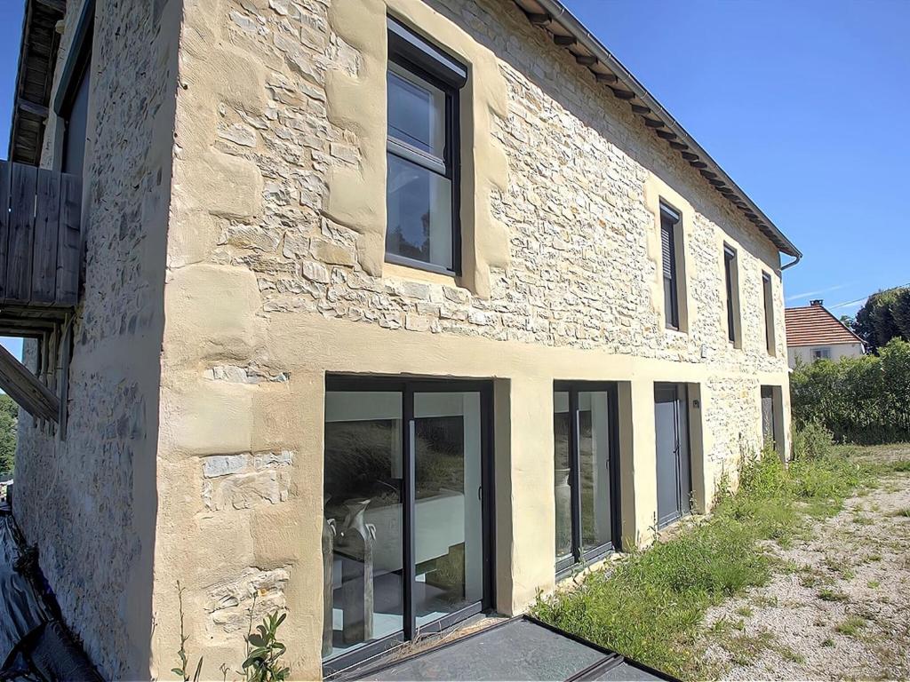 een stenen gebouw met grote glazen ramen bij Inviting holiday home in Gourdon with terrace in Gourdon-en-quercy