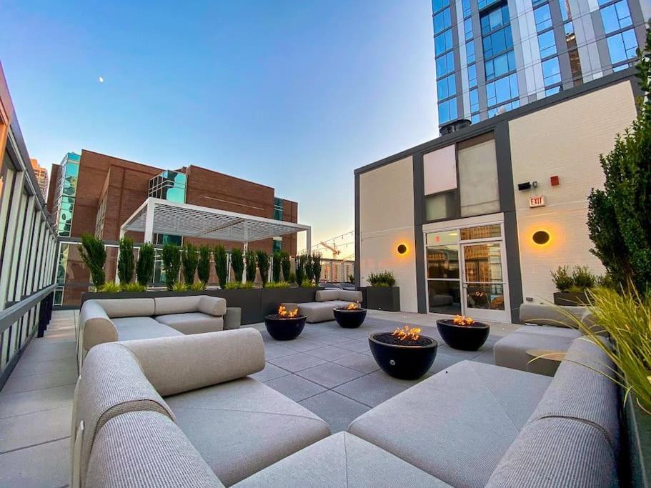 a patio with couches and fire pits on a building at Luxury Gold Coast Home w/ Rooftop Pool & Gym in Chicago
