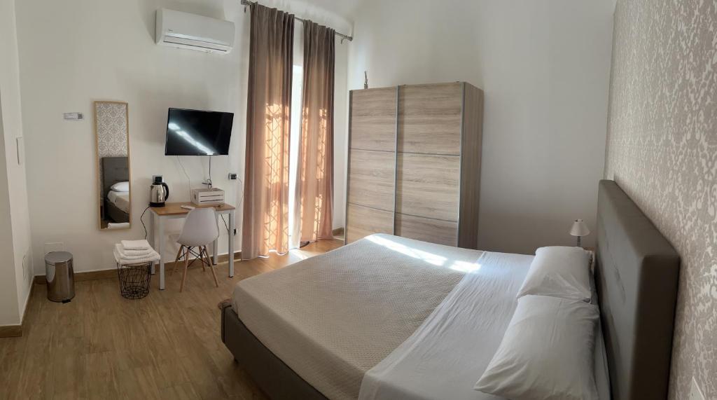 - une chambre avec un lit et un bureau dans l'établissement B&b Vesuviano, à Ercolano