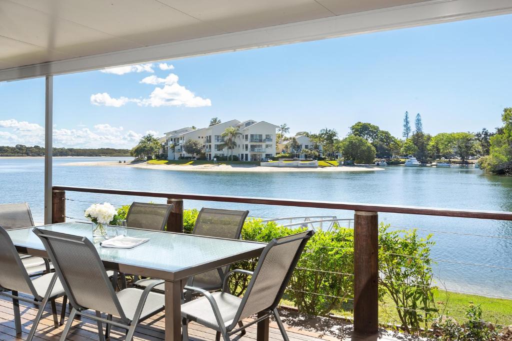 a table and chairs on a balcony with a view of a river at Noosa Haven Apt 6 Riverside Retreat in Noosaville