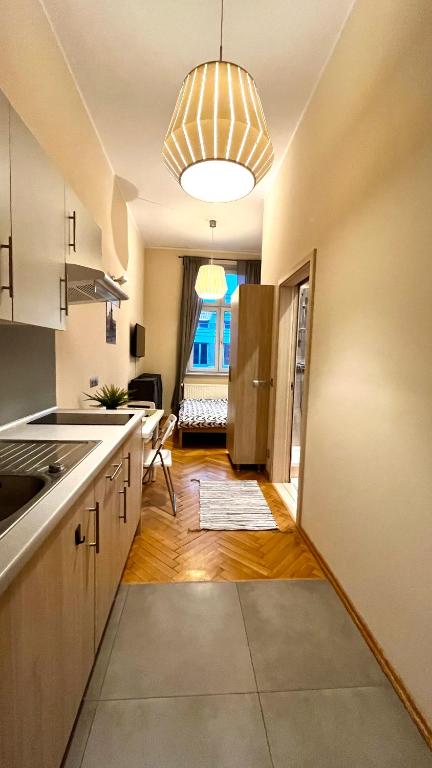 a kitchen with a sink and a refrigerator at Homely Studio in Krakow