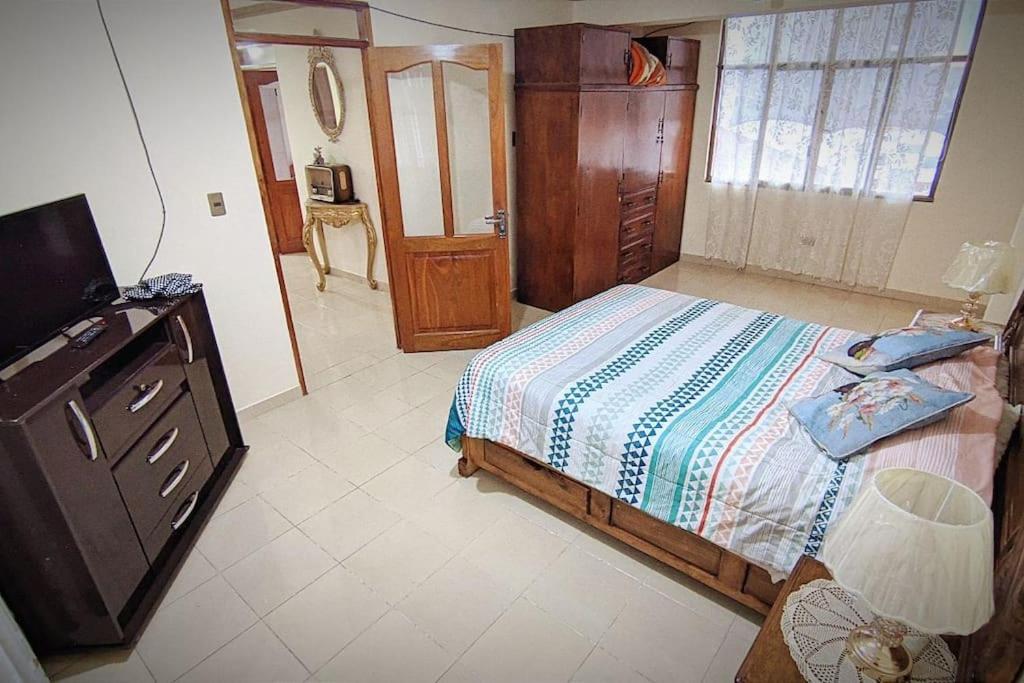 1 dormitorio con 1 cama, vestidor y TV en ¡Apartamento Espacioso!, en Sucre