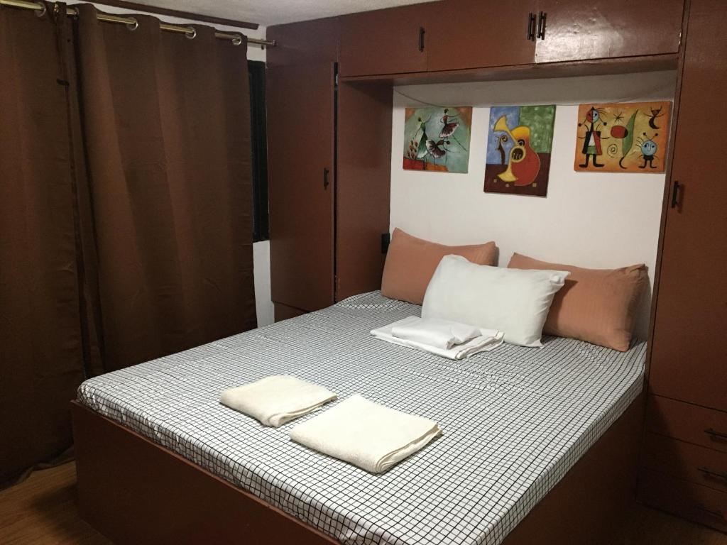 a bedroom with a bed with two towels on it at StayinManila in Pasig