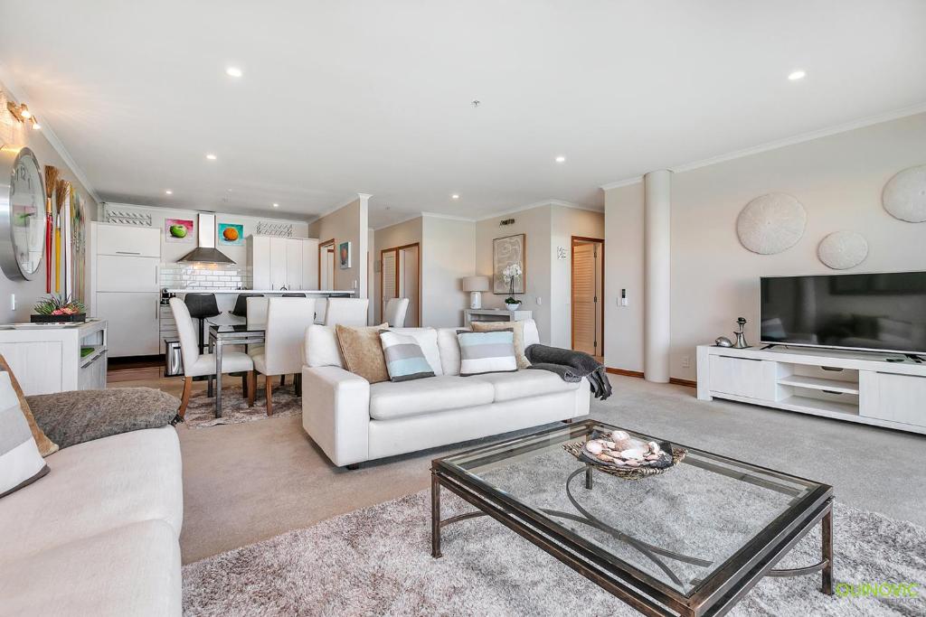 ein Wohnzimmer mit einem Sofa und einem Tisch in der Unterkunft QV Upmarket Waterfront Apartment - 787 in Auckland