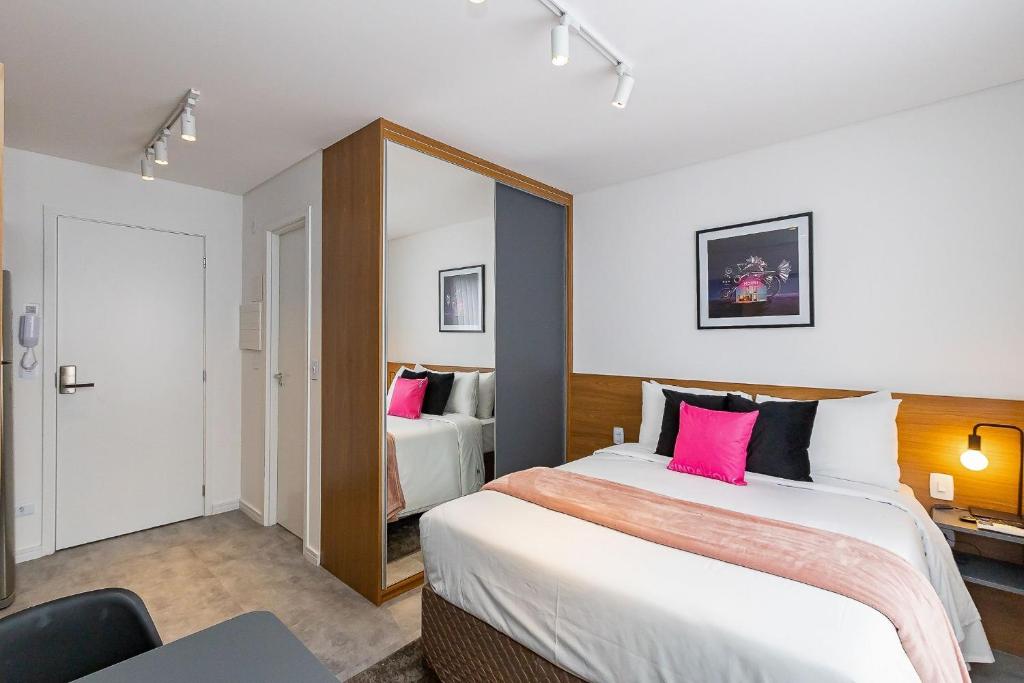 Habitación de hotel con 2 camas y almohadas rosas en Housi Brickell One - HBO0105 en Curitiba