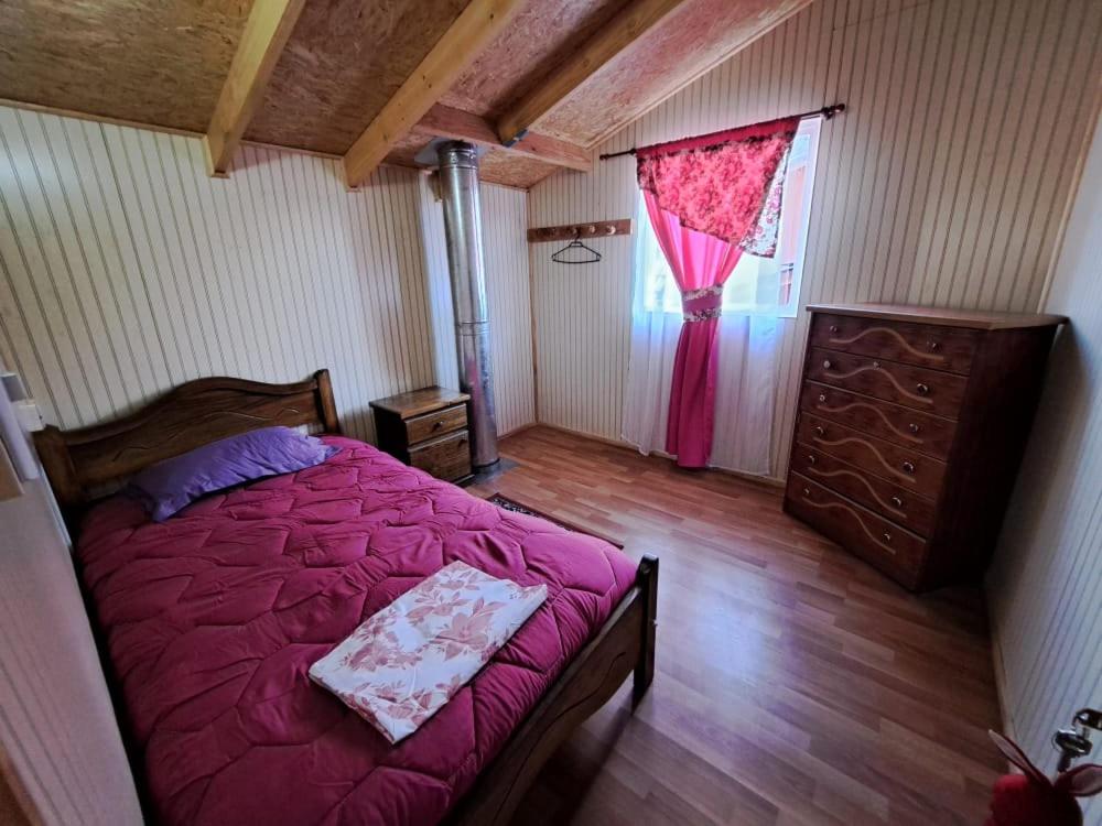 een slaapkamer met een bed, een dressoir en een raam bij Normita cabaña in Villa Cerro Castillo