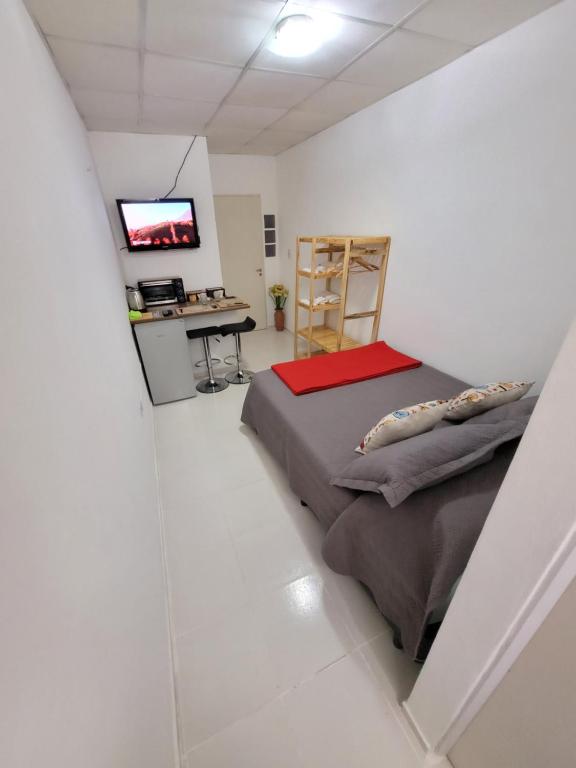 Habitación blanca con cama y TV en Departamento - M I N I D O en Resistencia