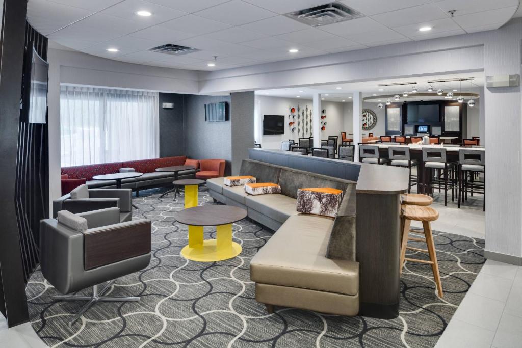 a hotel lobby with a waiting area and a bar at SpringHill Suites Milford in Milford