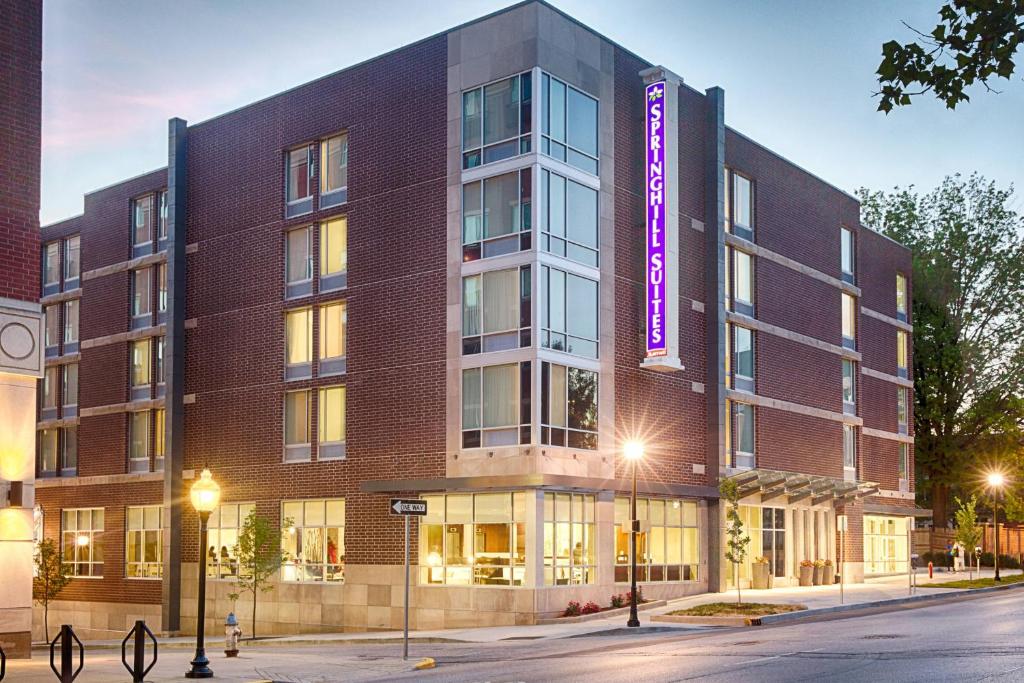 a large brick building with a purple sign on it at SpringHill Suites by Marriott Bloomington in Bloomington