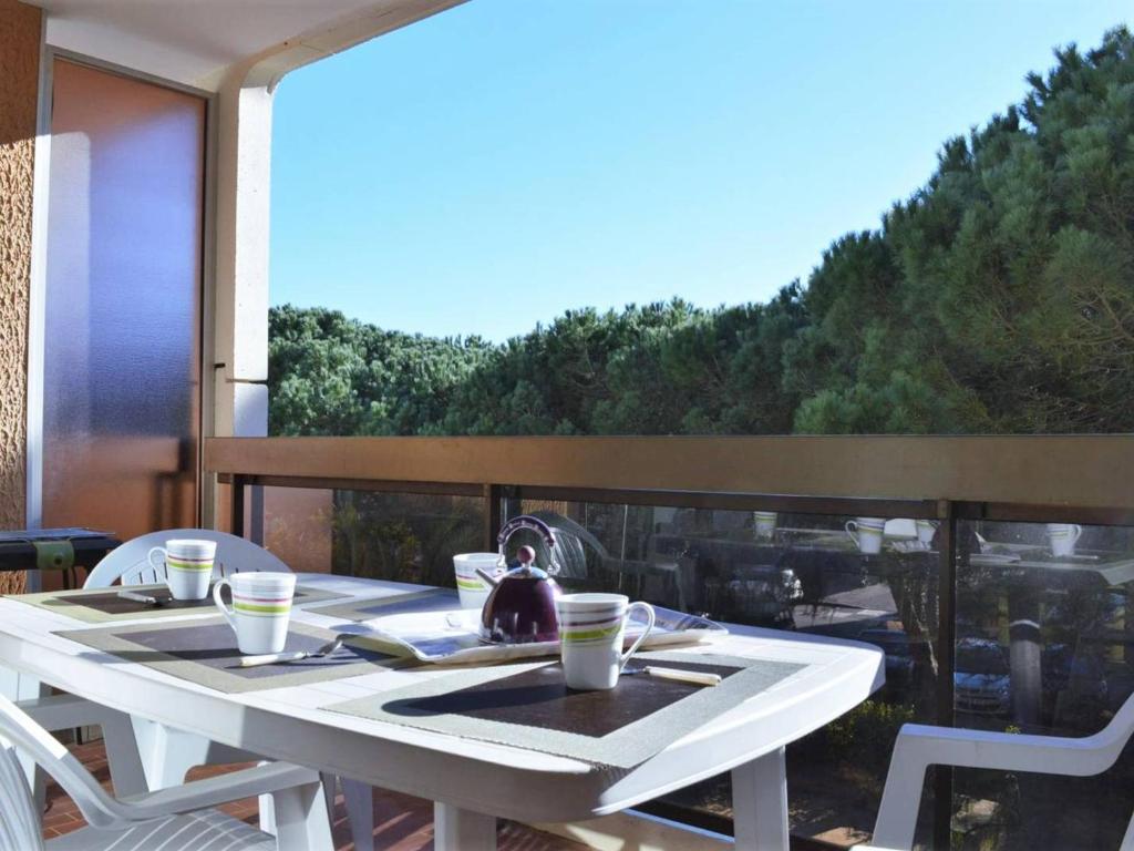 - une table blanche sur un balcon avec vue dans l'établissement Appartement T2 Cabine avec Terrasse, 5 Couchages, Parking Privé – Bormes les Mimosas - FR-1-251-503, à Bormes-les-Mimosas