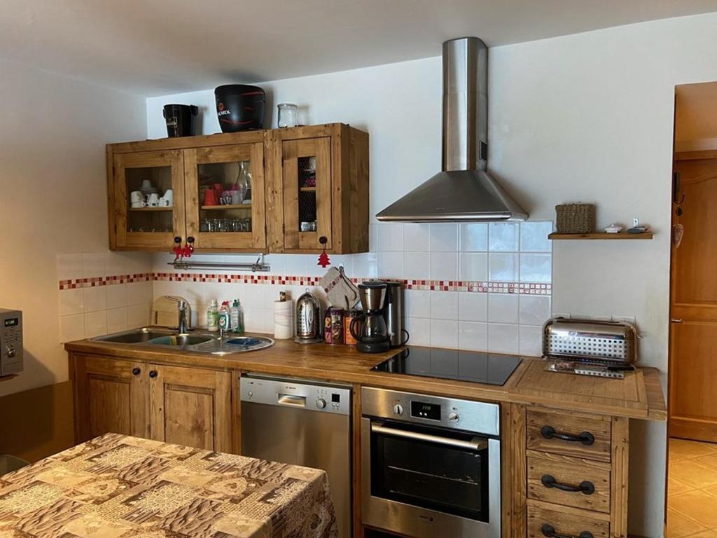 une cuisine avec un évier et une cuisinière four supérieur dans l'établissement Appartement 3 pièces avec piscine et parking, jusqu'à 6 personnes - FR-1-733-128, à Crest-Voland