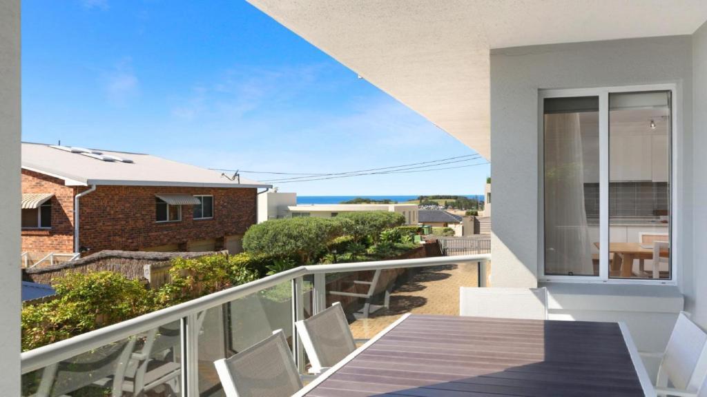 a balcony with a table and chairs on a balcony at Moon Glow Views, Short Walk To Beach Accom Holidays in Terrigal
