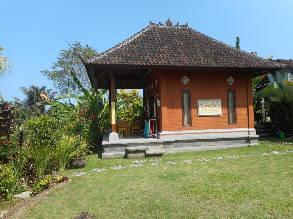 a small building with a sign on it in a yard at Cegeng Lestari Guesthouse in Sidemen