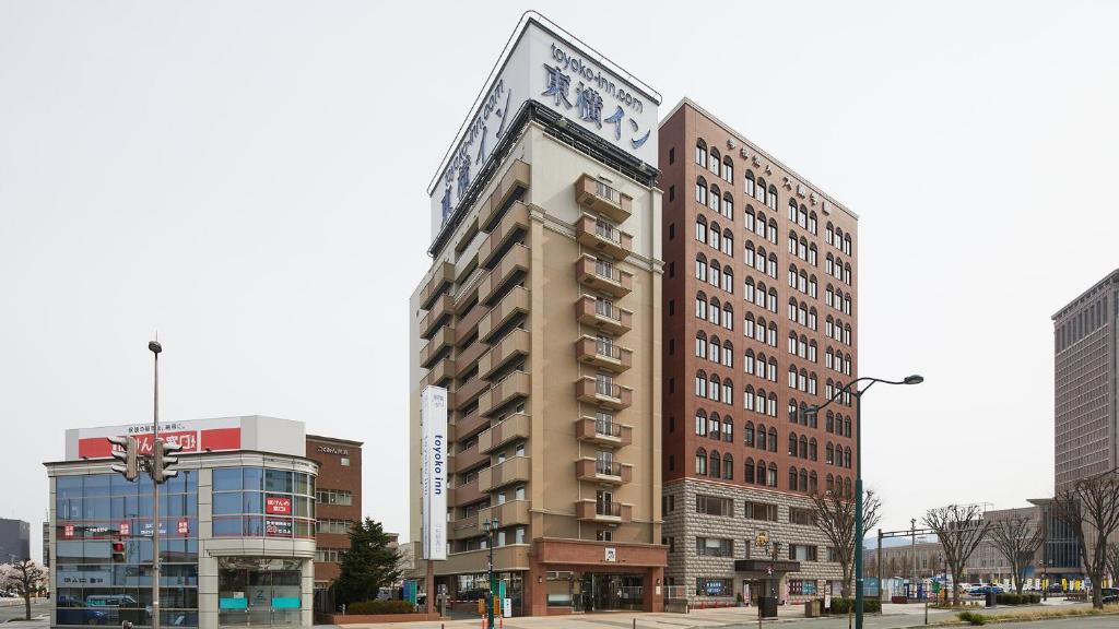 un bâtiment avec une horloge sur son côté dans l'établissement Toyoko Inn Yamagata-eki Nishi-guchi, à Yamagata