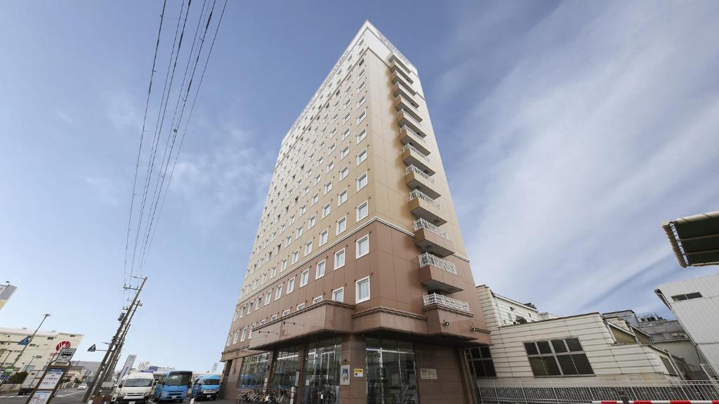 Toyoko Inn Chiba Makuhari في شيبا: مبنى طويل على زاوية شارع