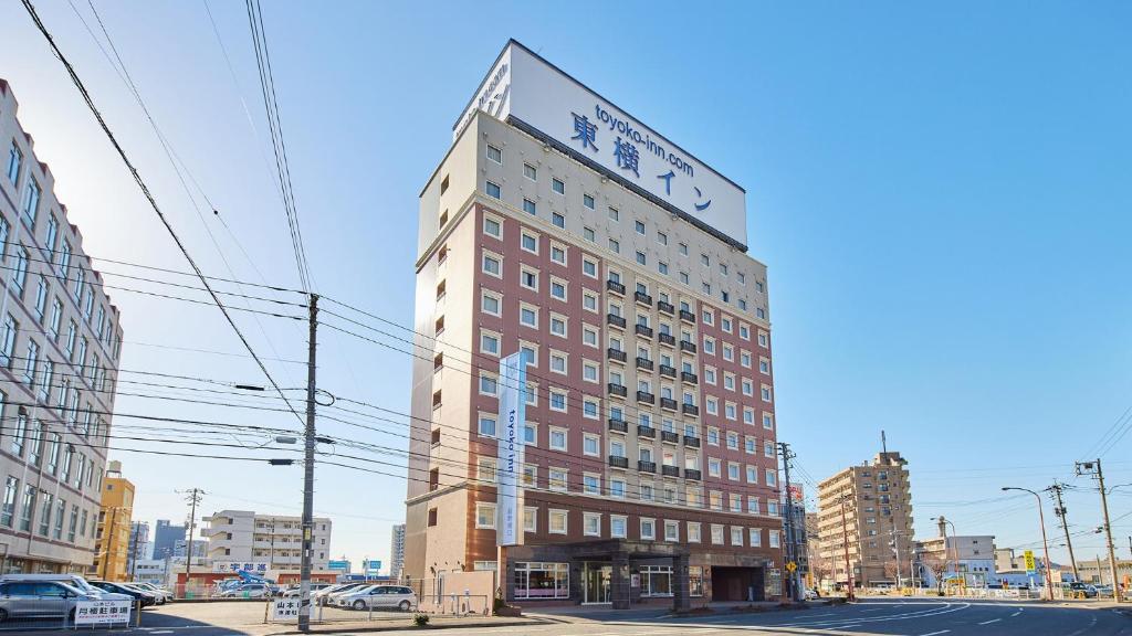 un edificio alto con un reloj encima en Toyoko Inn Shin-yamaguchi-eki Shinkansen-guchi en Yamaguchi