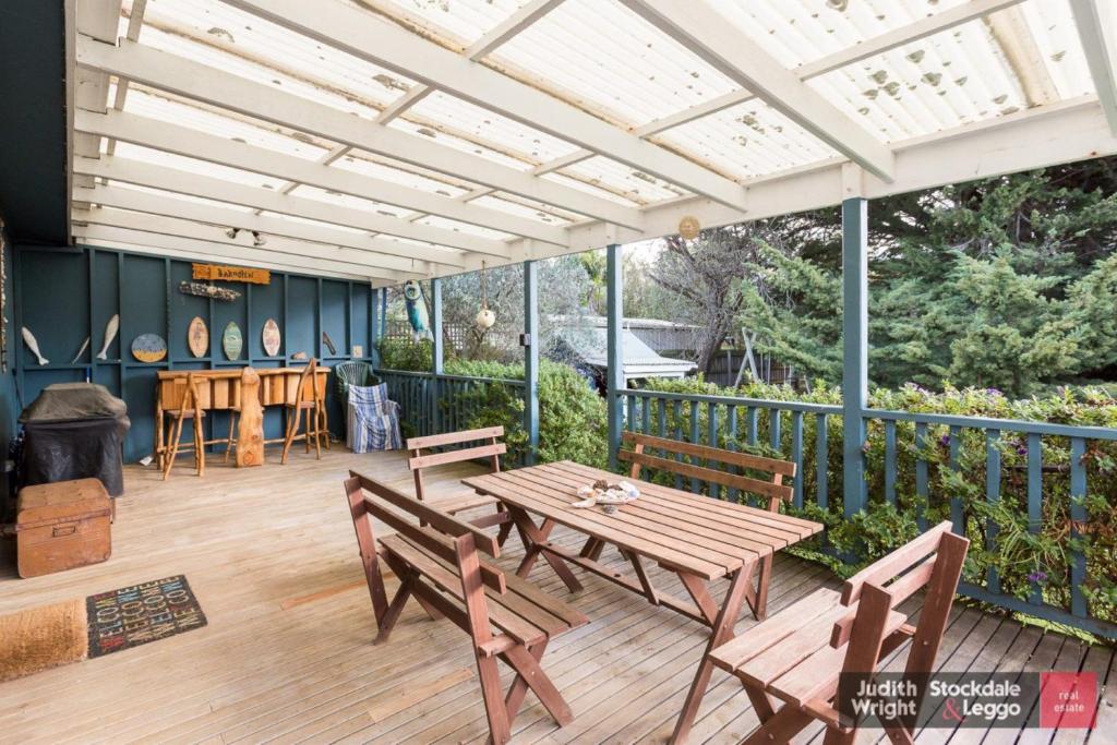 a patio with a wooden table and chairs on a deck at Heyley Haven in Ventnor
