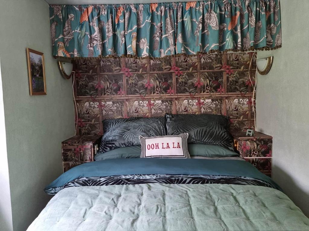 een bed met een getuft hoofdeinde met een notitiebord bovenop bij Durham Donkey Rescue Showman's Wagon in Durham