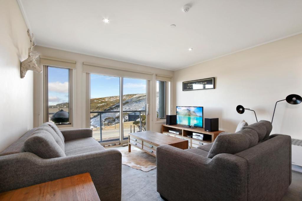 a living room with two couches and a television at White Crystal 206 in Mount Hotham
