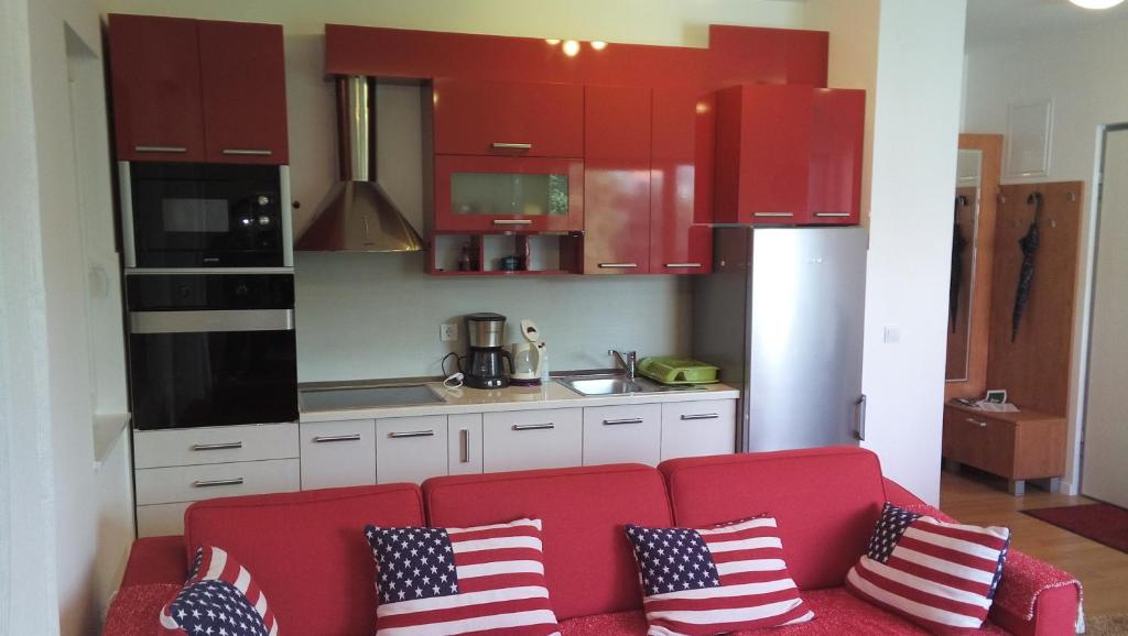 una cocina con un sofá rojo con almohadas patrióticas. en Apartment Irma, en Dubrovnik