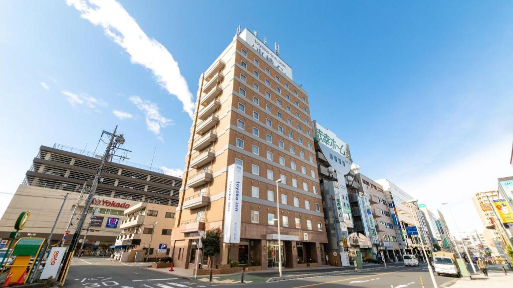 een hoog gebouw op de hoek van een stadsstraat bij Toyoko Inn Wako-shi Ekimae in Wako