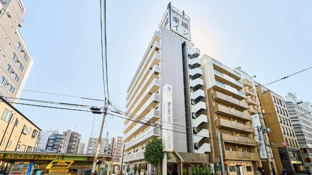 大阪的住宿－Toyoko Inn Shin-Osaka Chuo-guchi Honkan，一座高大的建筑,上面有钟