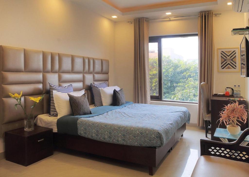a bedroom with a large bed with a large window at Park Studio DLF Phase 2, Cyber City, Gurgaon in Gurgaon