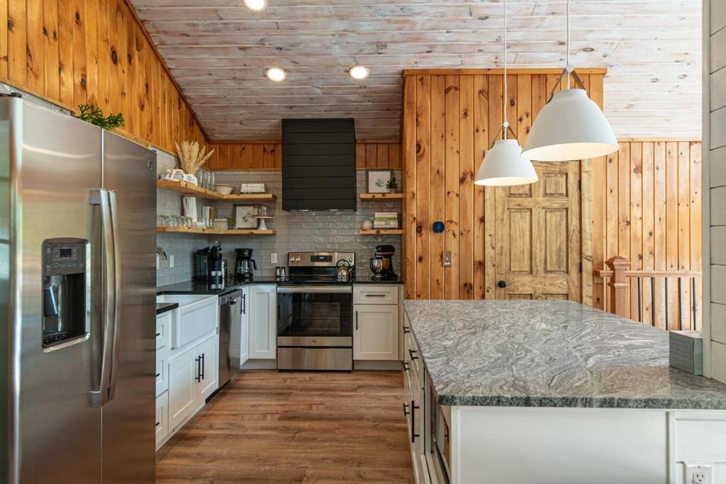 a kitchen with white appliances and wooden walls at Hidden Mountain Gem in Gatlinburg