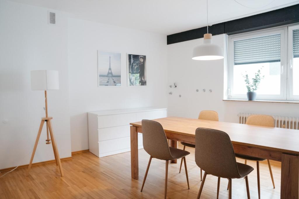 uma sala de jantar com mesa e cadeiras de madeira em F&E Apartment - groß, freundlich hell em Fellbach