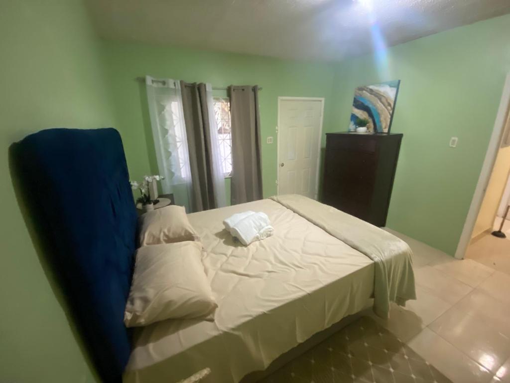a bedroom with a bed with a blue head board at Best believe house 