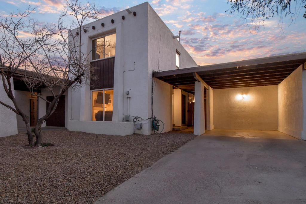 una casa blanca con un garaje y un árbol en The Villa - An Irvie Home, en Albuquerque