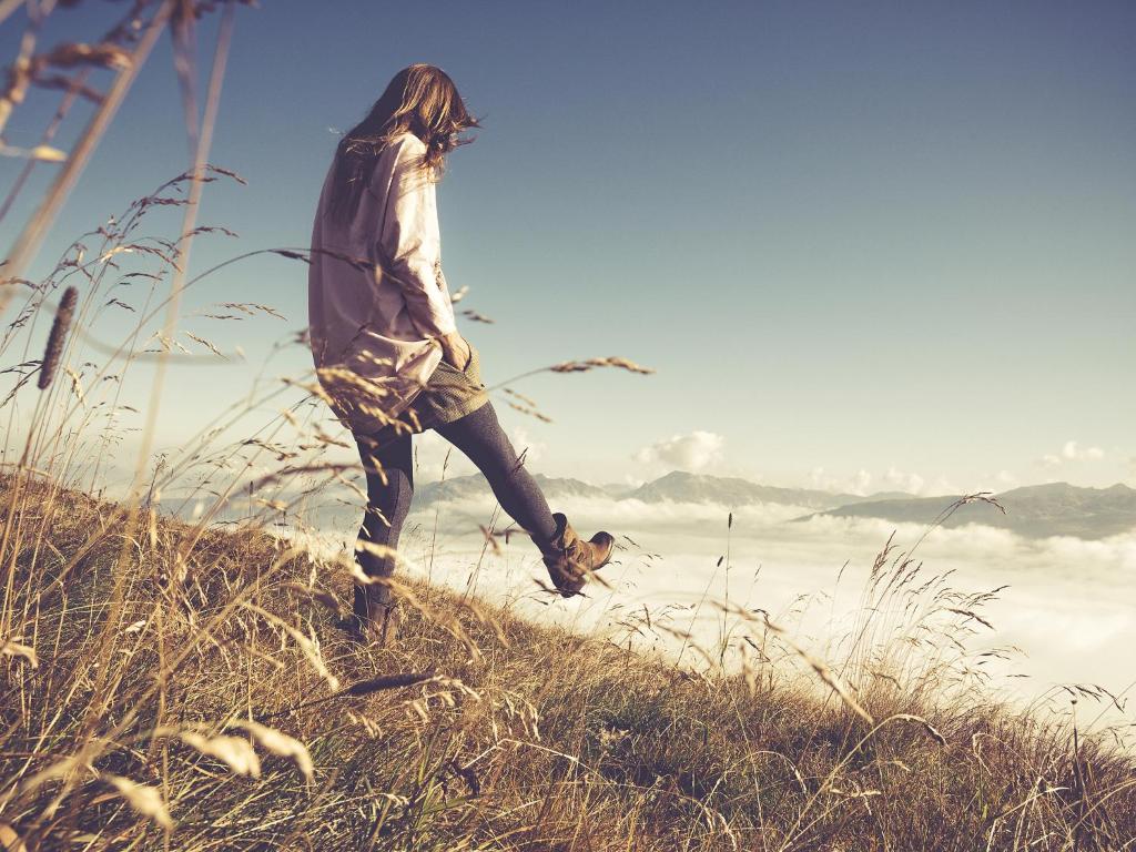 a woman walking up a hill in the grass at Neschtl in Ramsau im Zillertal