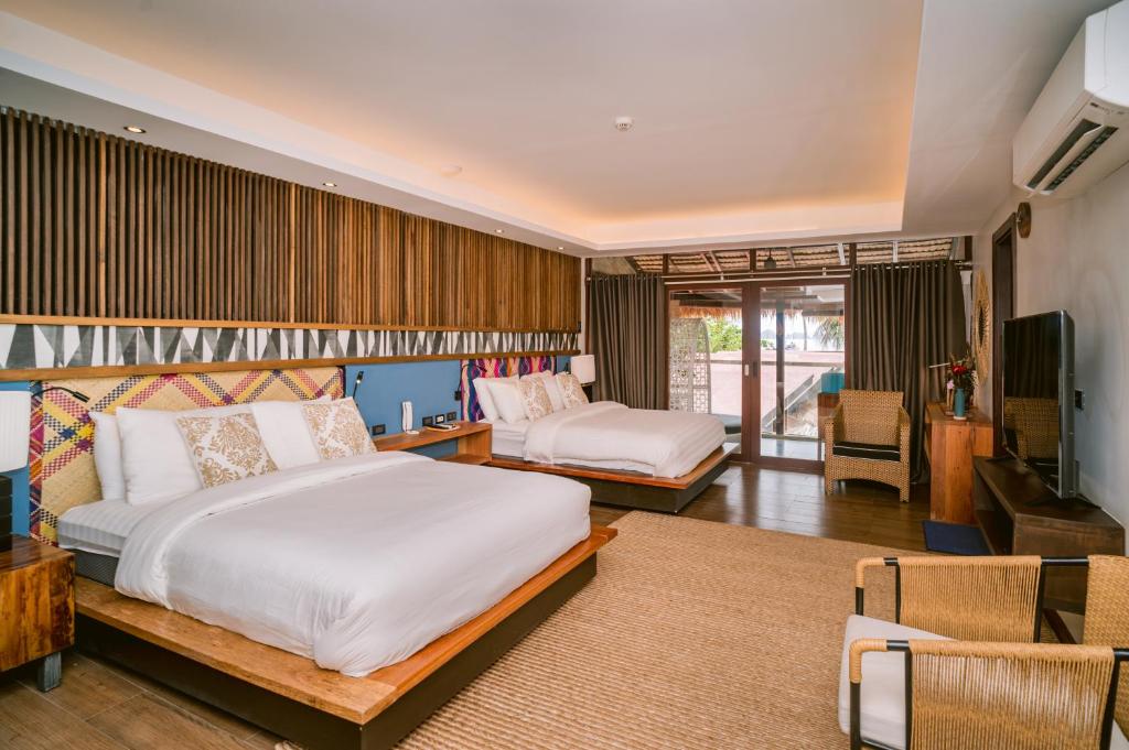 1 dormitorio con 2 camas y sala de estar en Banig Beach Resort El Nido, en El Nido