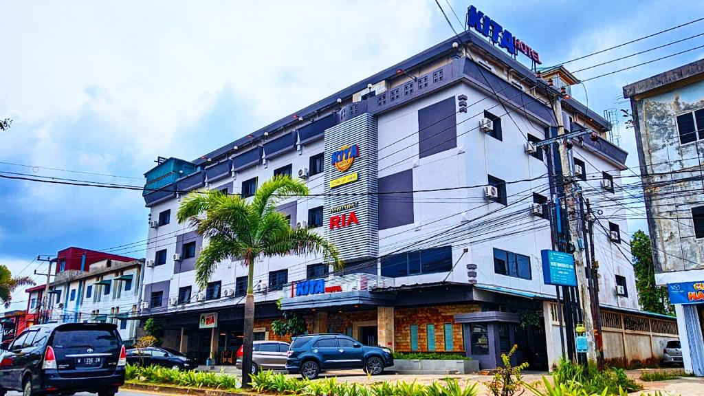 ein Gebäude auf einer Straße mit davor geparkt in der Unterkunft Kita Hotel in Tanjung Pinang 