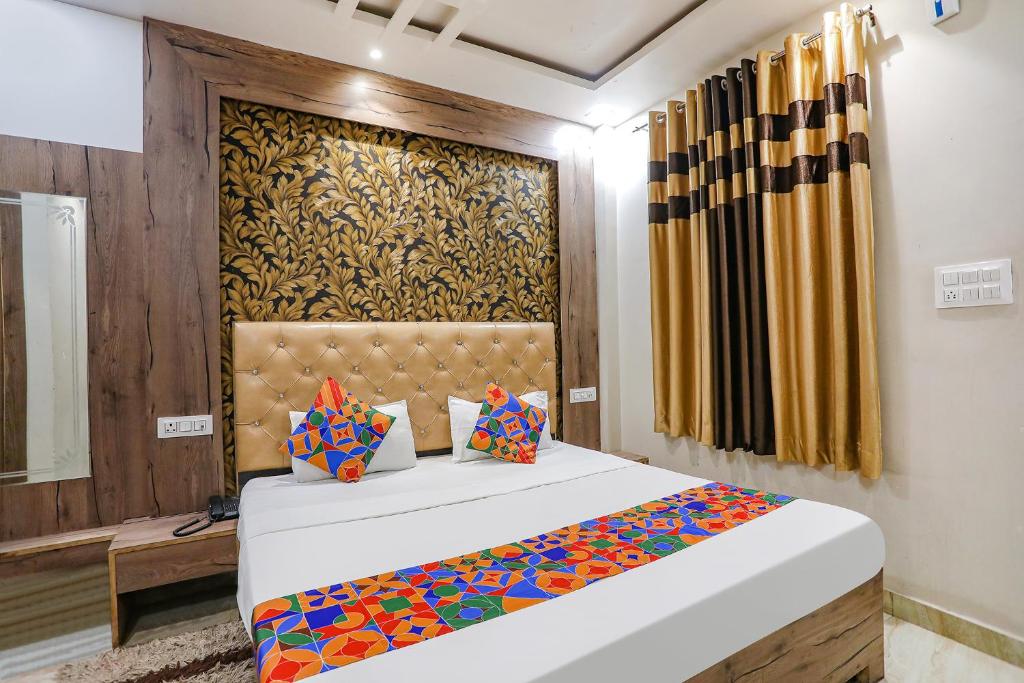 a bedroom with a bed with a colorful comforter at FabExpress Shri Ram Kashi in Prayagraj