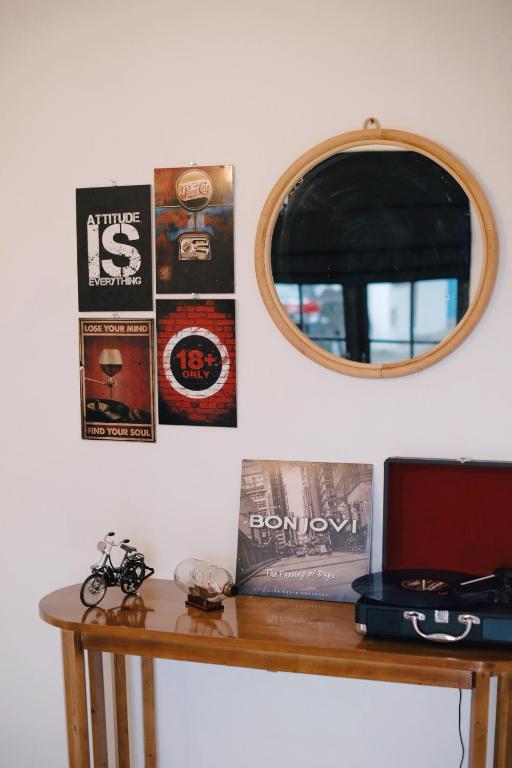a table with a mirror and posters on the wall at D Black Houze Banyuwangi in Banyuwangi