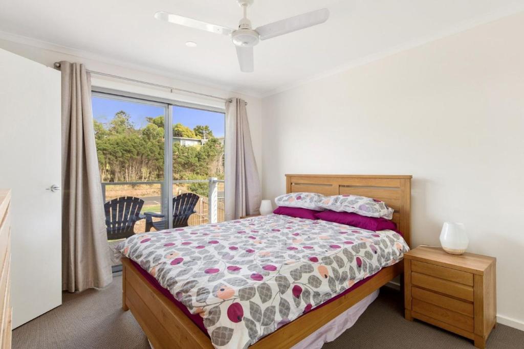 een slaapkamer met een bed en een raam bij 187 Smiths Beach Road Smiths Beach in Smiths Beach