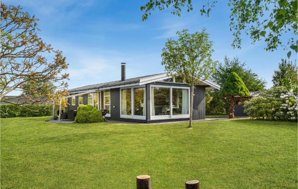 een huis met grote ramen en een tuin bij Stunning Home In Dronningmlle With Kitchen in Dronningmølle