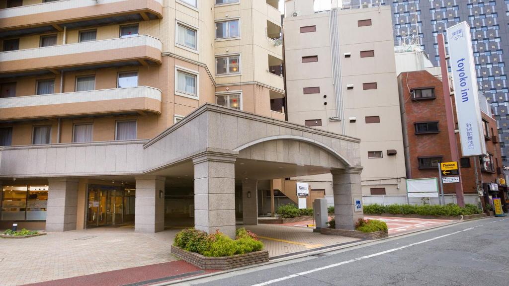 ein Gebäude mit einem Bogen in der Mitte einer Straße in der Unterkunft Toyoko Inn Tokyo Shinjuku Kabukicho in Tokio